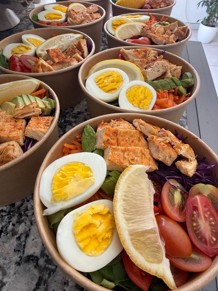 Ensaladas saludables en bowls con pollo, huevo, palta y tomate cherry